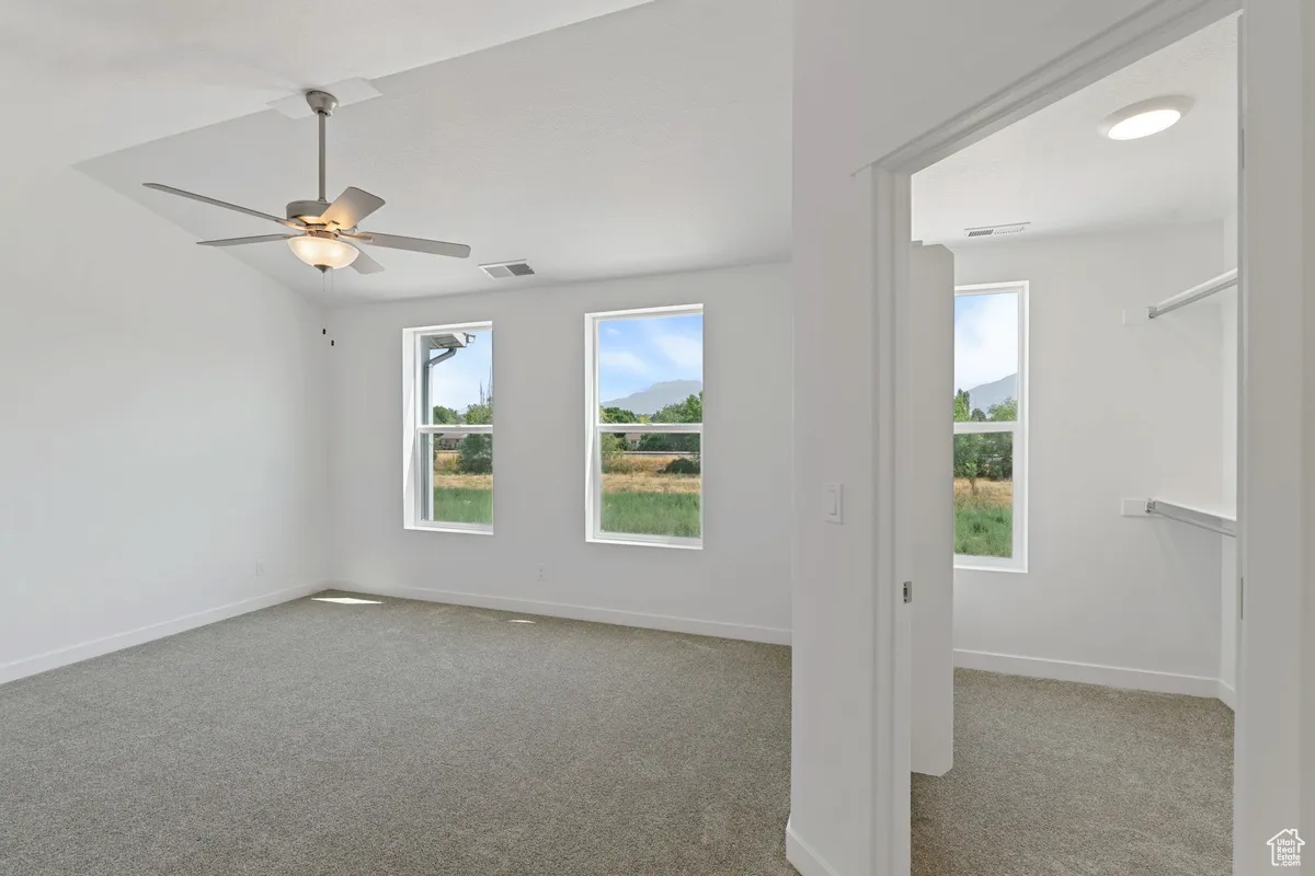 Empty room featuring carpet and a ceiling fan