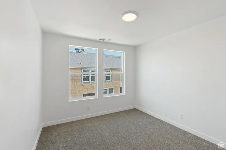 Carpeted spare room with baseboards