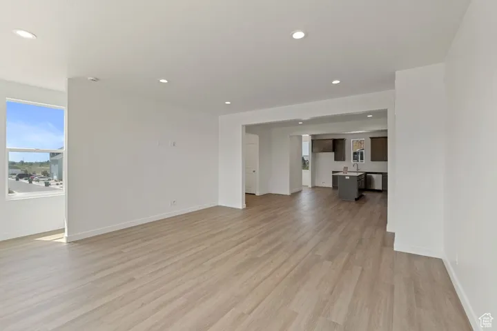 Unfurnished living room featuring light wood-type flooring and recessed lighting