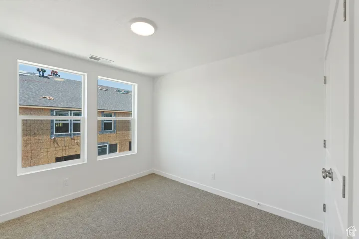 Empty room with carpet and baseboards
