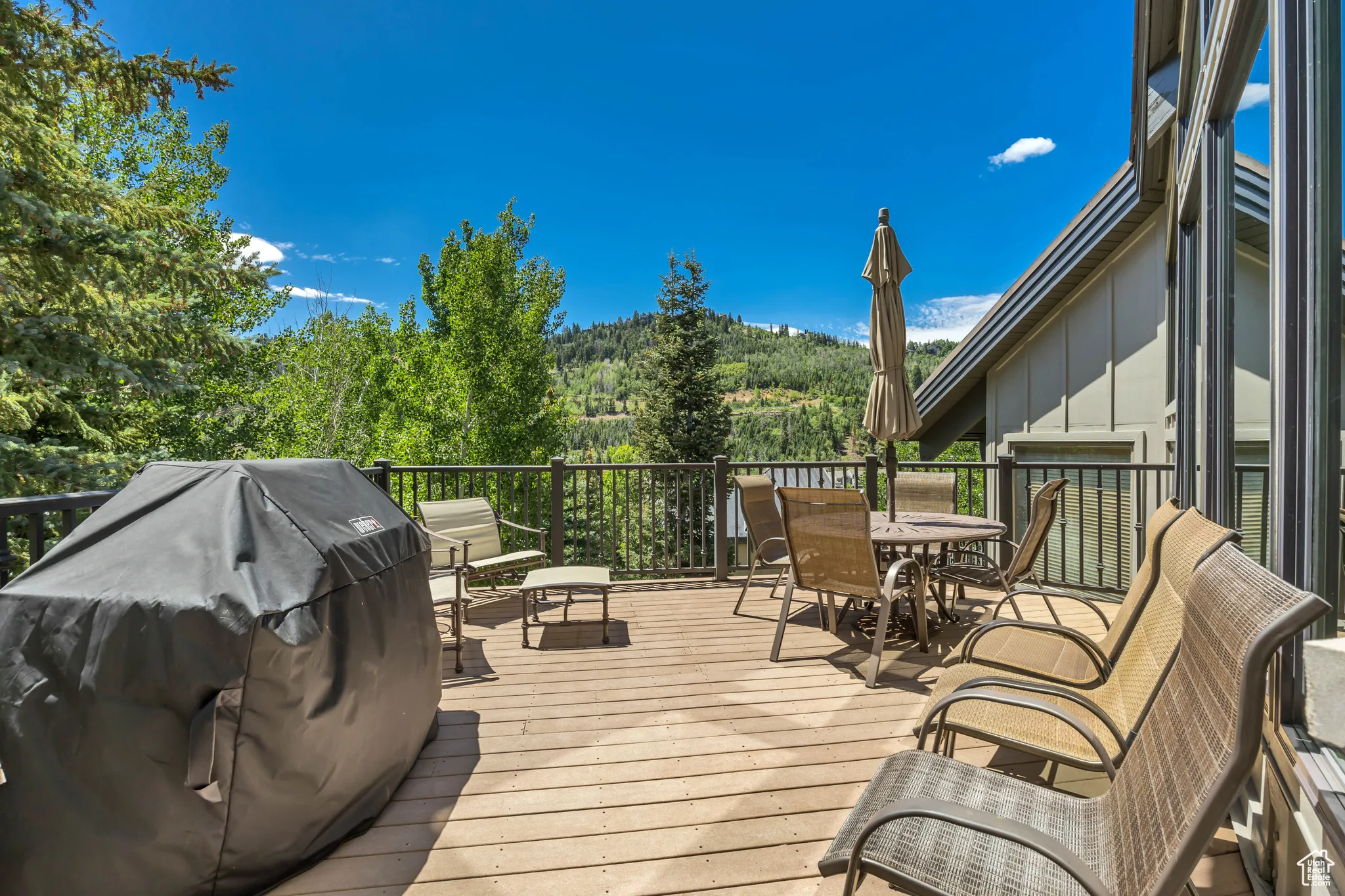 Wooden deck featuring grilling area and outdoor dining space
