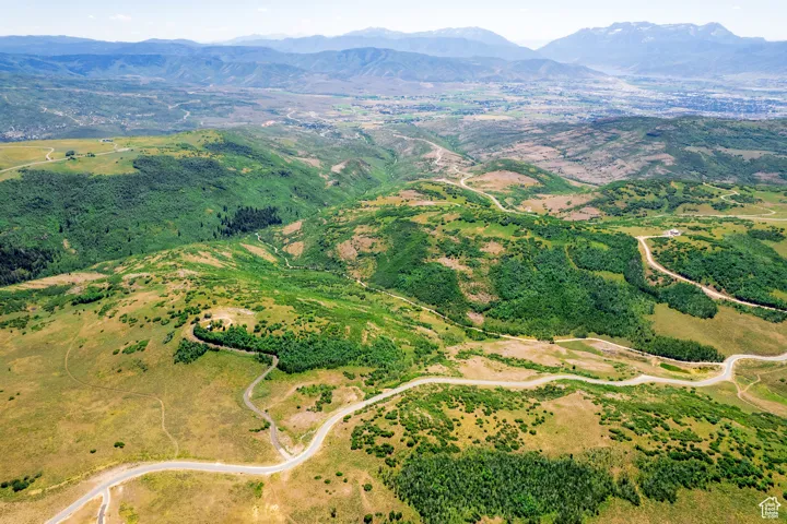 Aerial view of property and surrounding area featuring mountains