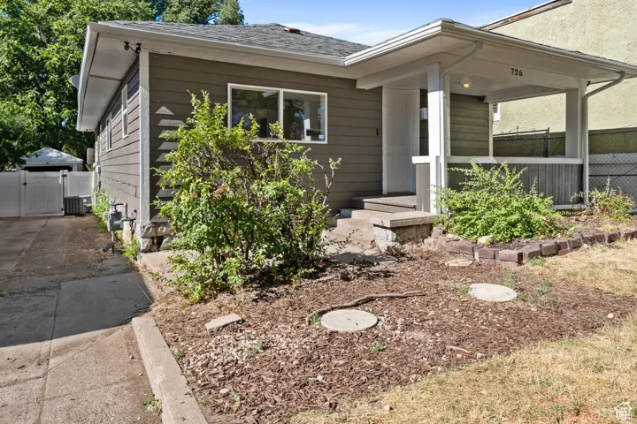View of front of property with a gate and roof with shingles
