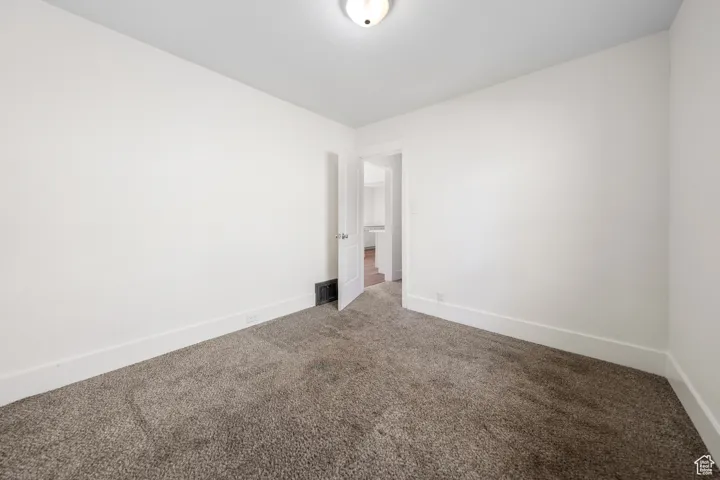 Empty room featuring light carpet