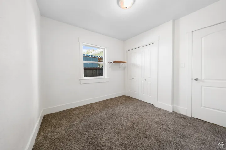 Unfurnished bedroom with carpet and a closet
