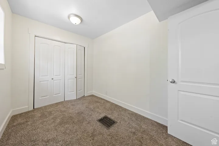 Unfurnished bedroom with carpet flooring and a closet