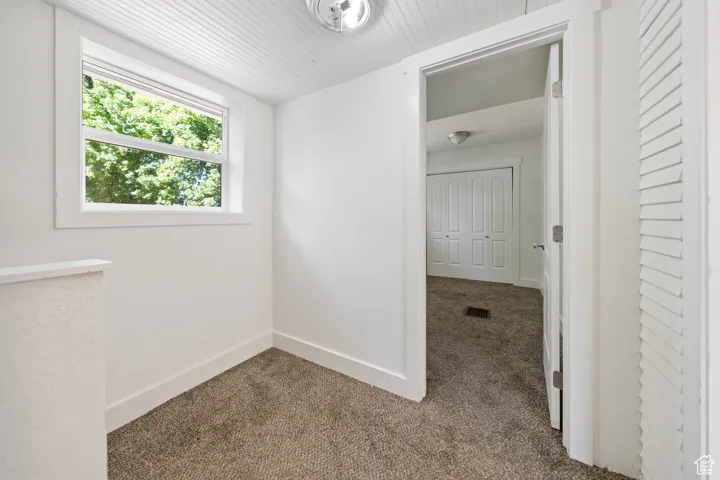 Unfurnished room with carpet flooring and baseboards