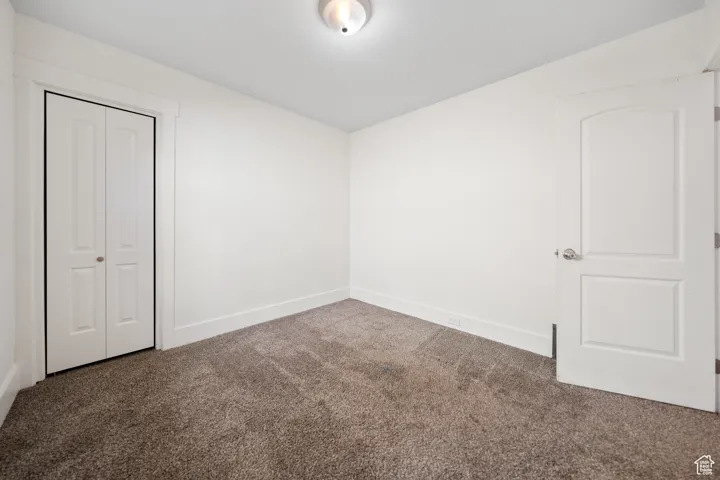 Unfurnished bedroom with carpet and a closet