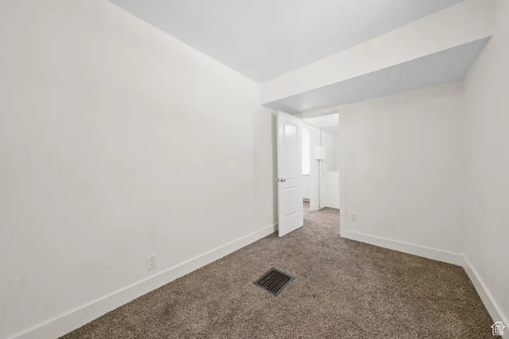 Empty room with carpet and baseboards