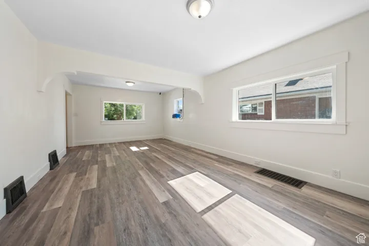 Spare room featuring wood finished floors and arched walkways