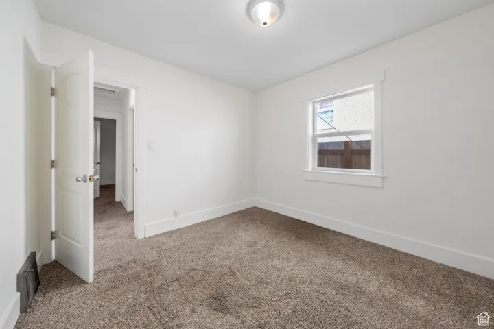 Carpeted spare room with baseboards