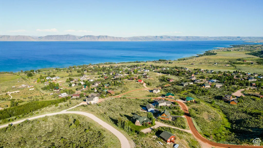 Aerial view of property and surrounding area with a water and mountain view