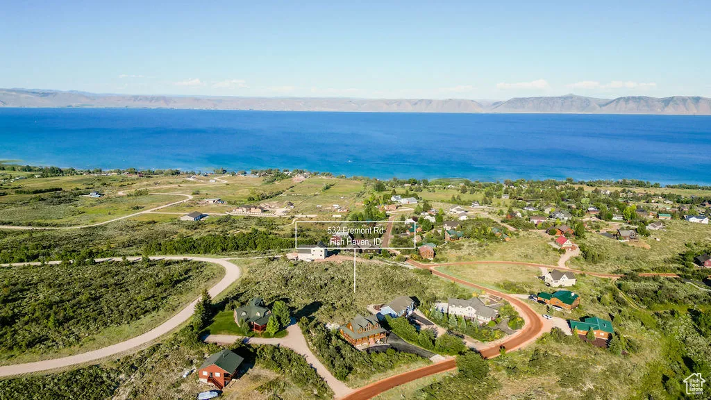 Aerial view of property and surrounding area featuring a water and mountain view
