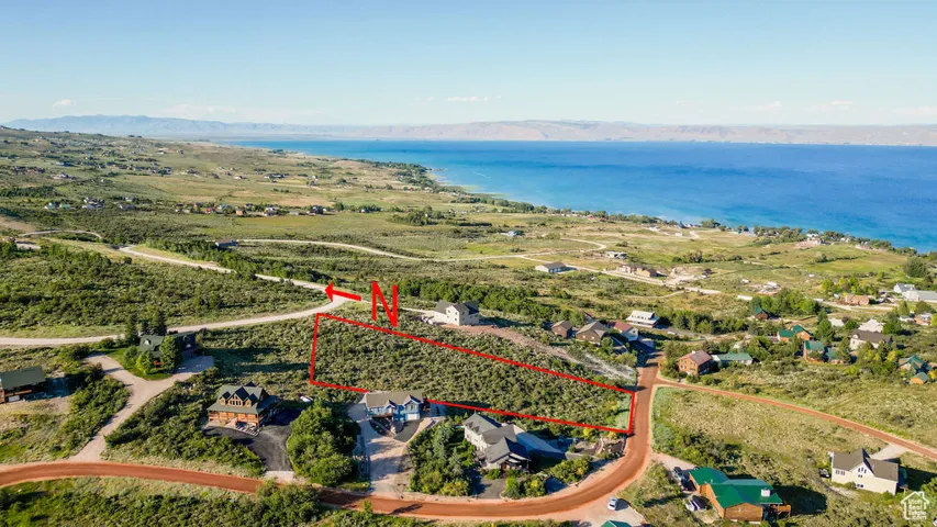 Aerial view of property and surrounding area featuring property boundaries highlighted and a water and mountain view