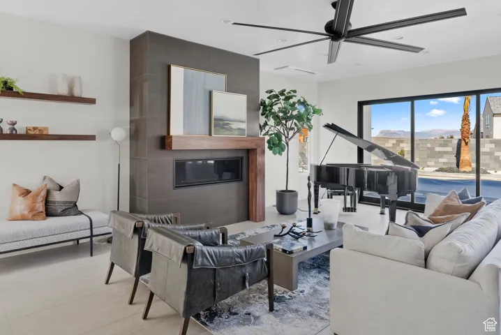 Living area featuring a ceiling fan and a large fireplace
