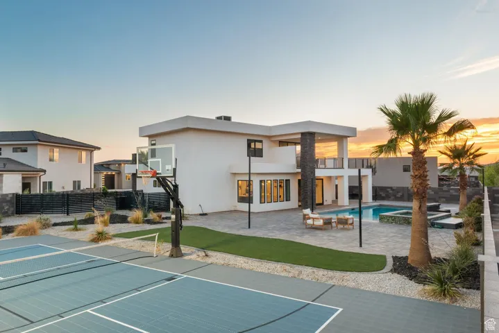 View of sport court featuring a pool with connected hot tub
