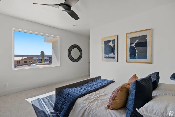 Carpeted bedroom with a ceiling fan