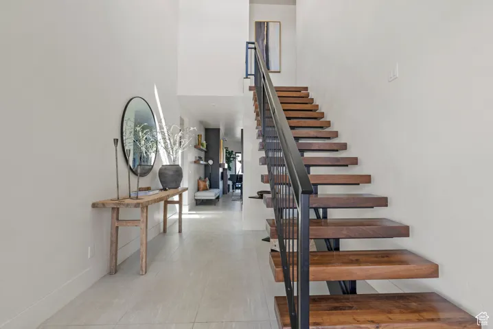 Stairs with a towering ceiling and tile patterned floors