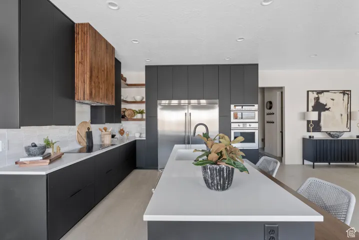 Kitchen featuring modern cabinets, dark cabinets, open shelves, light countertops, and tasteful backsplash