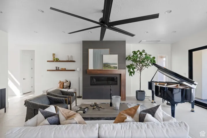 Living room featuring ceiling fan, recessed lighting, a textured ceiling, and a fireplace