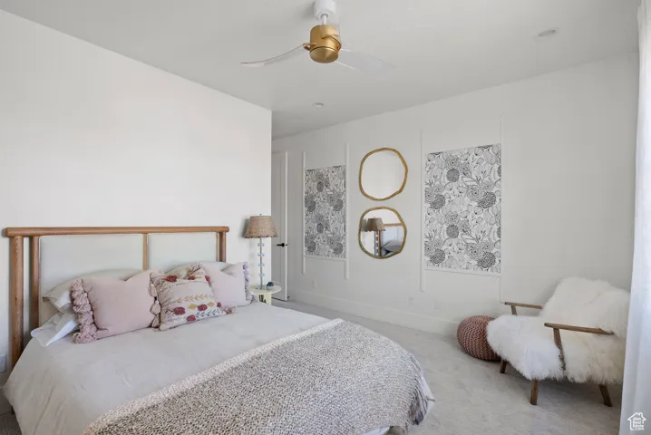 Carpeted bedroom with a ceiling fan