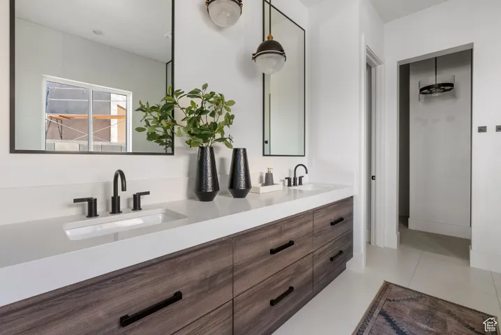 Bathroom with double vanity and tile patterned flooring