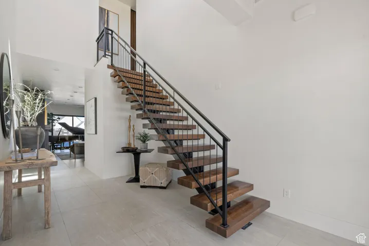 Staircase with a high ceiling and tile patterned floors