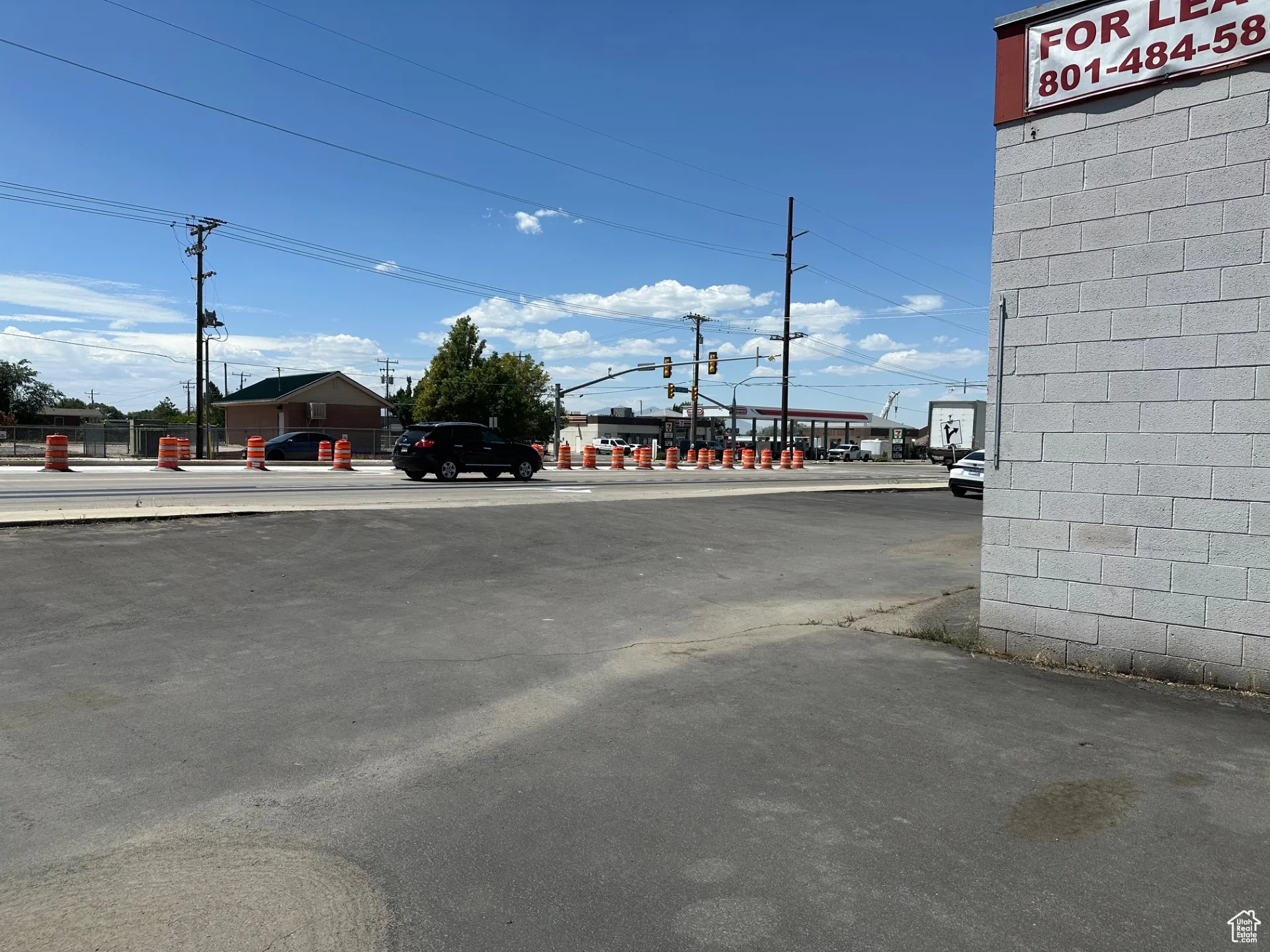 View of asphalt street featuring street lighting and sidewalks