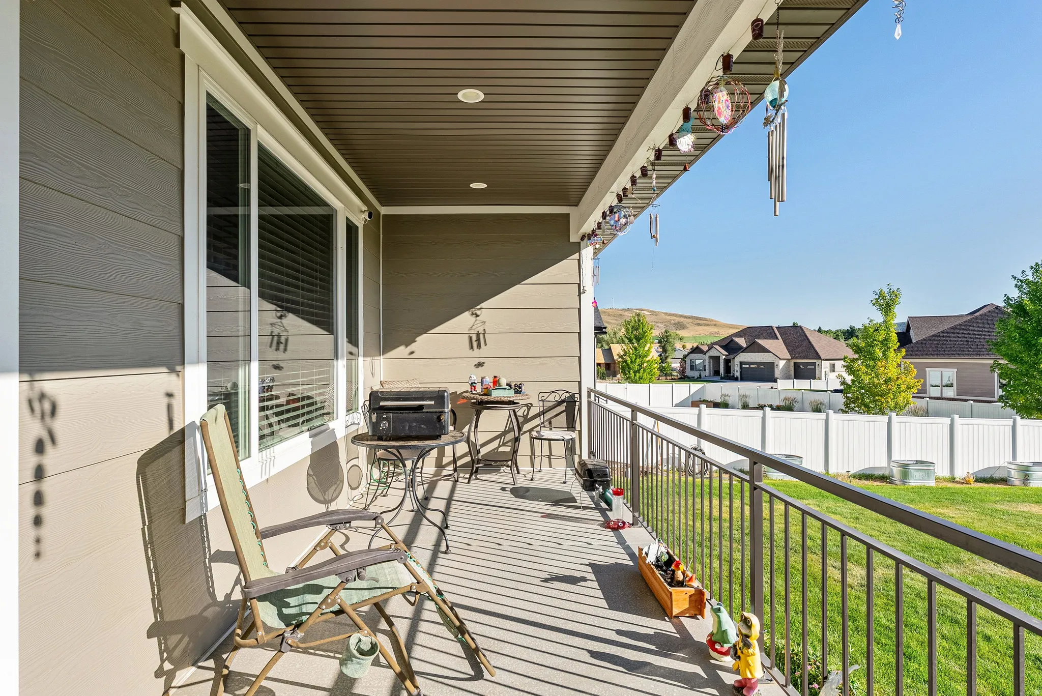 Covered outdoor patio featuring composite decking and a black metal railing