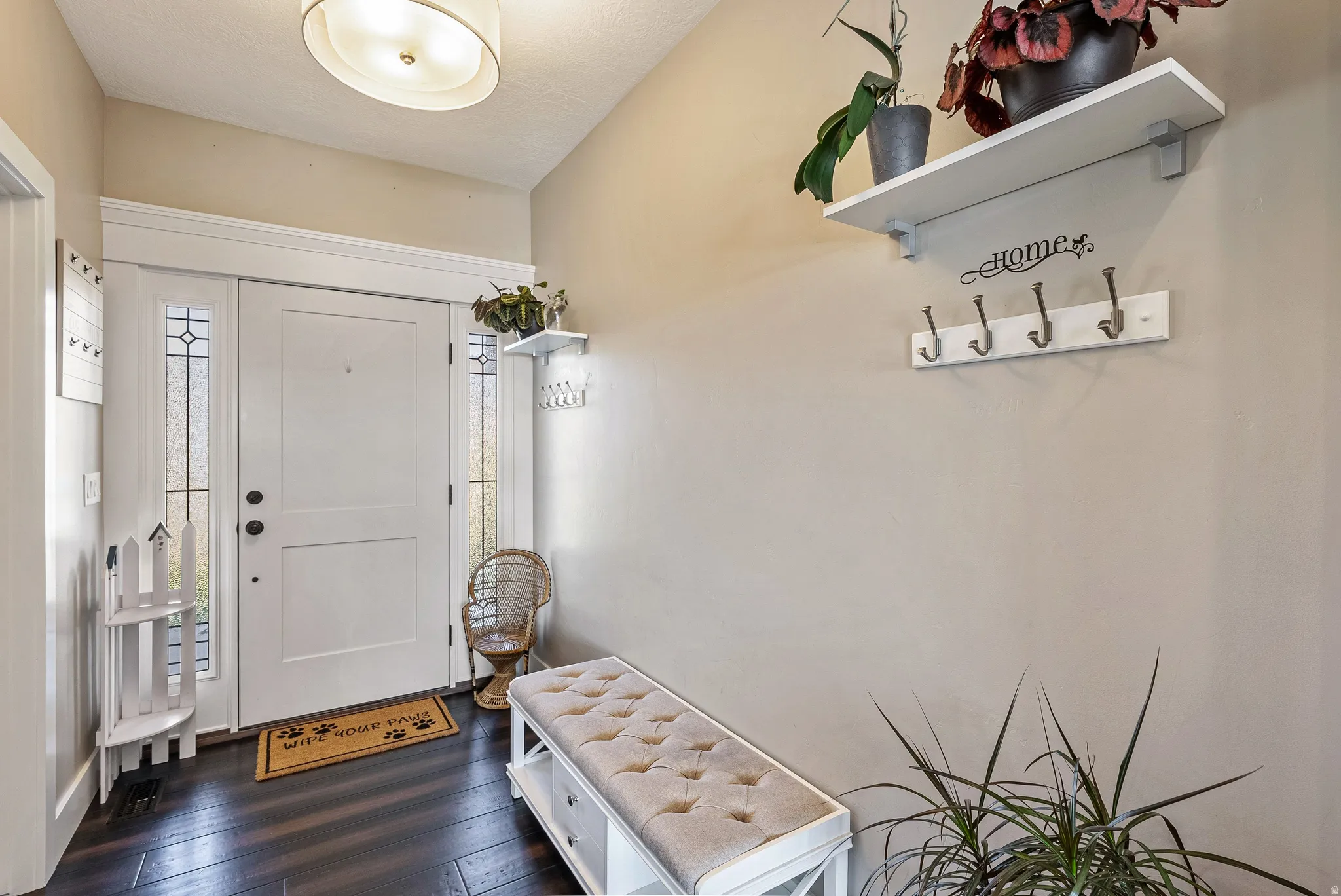 Entryway featuring a white paneled door with decorative sidelights, dark wood-finish flooring, and a flush-mount drum light fixture