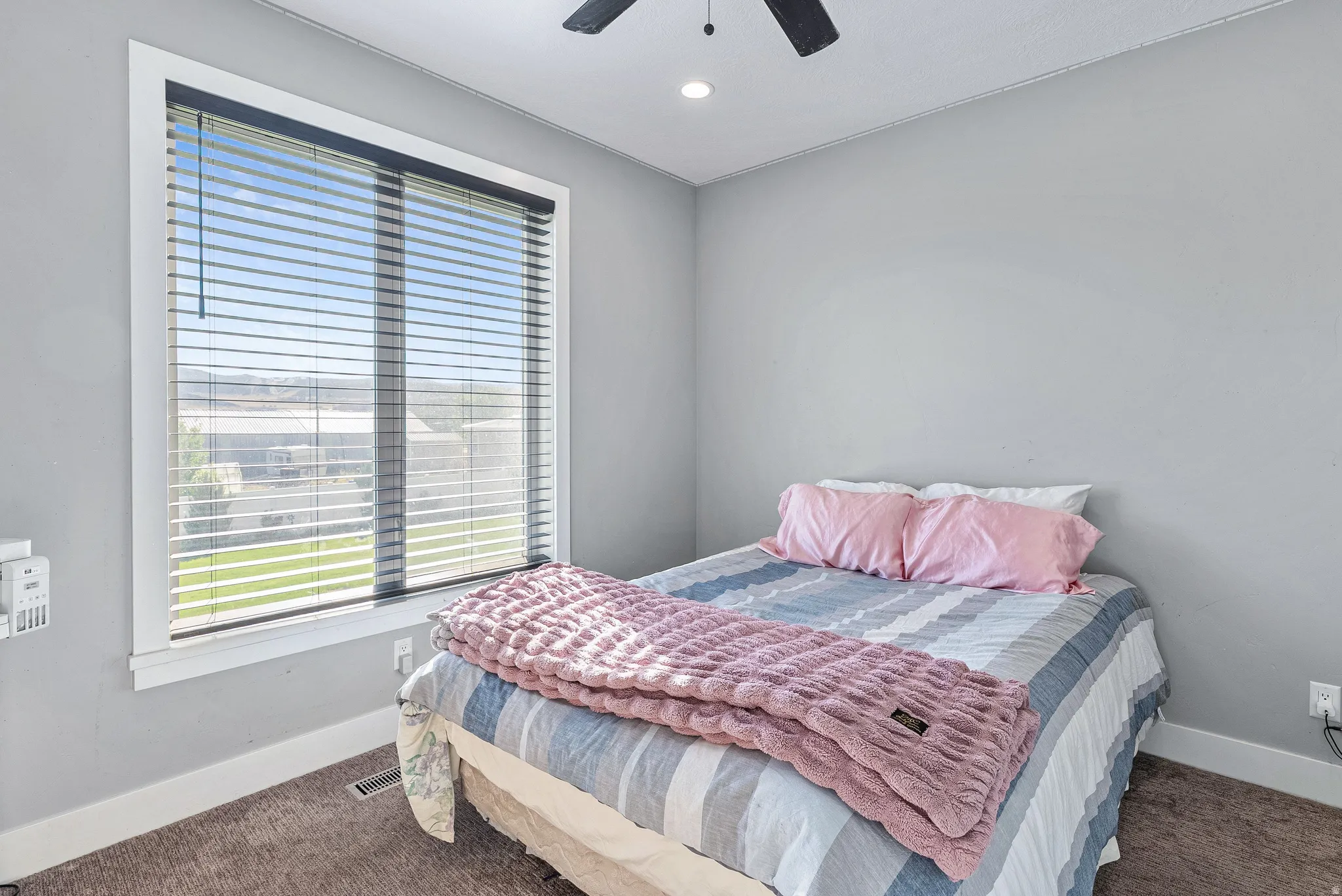 Bedroom featuring a large window with white trim, horizontal blinds, recessed lighting, and a ceiling fan