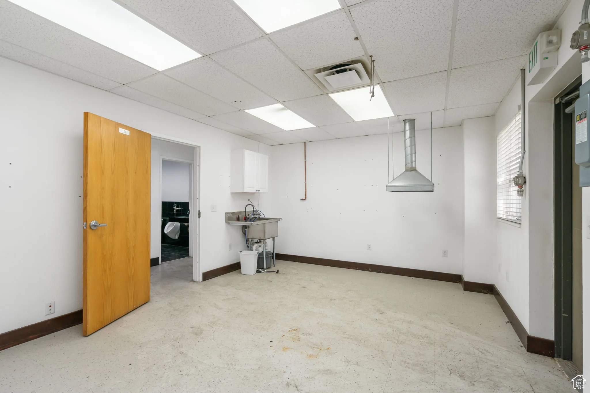 Basement with a drop ceiling and baseboards