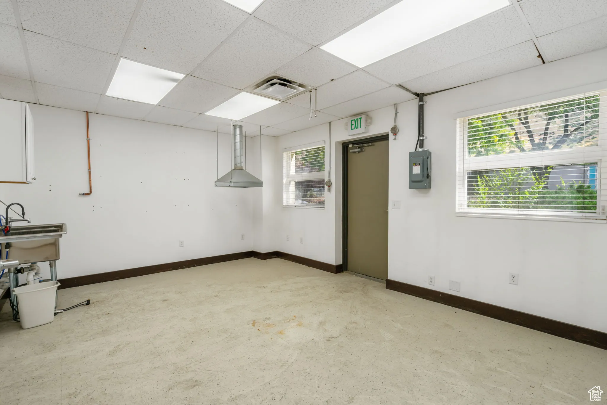 Basement with a drop ceiling and electric panel