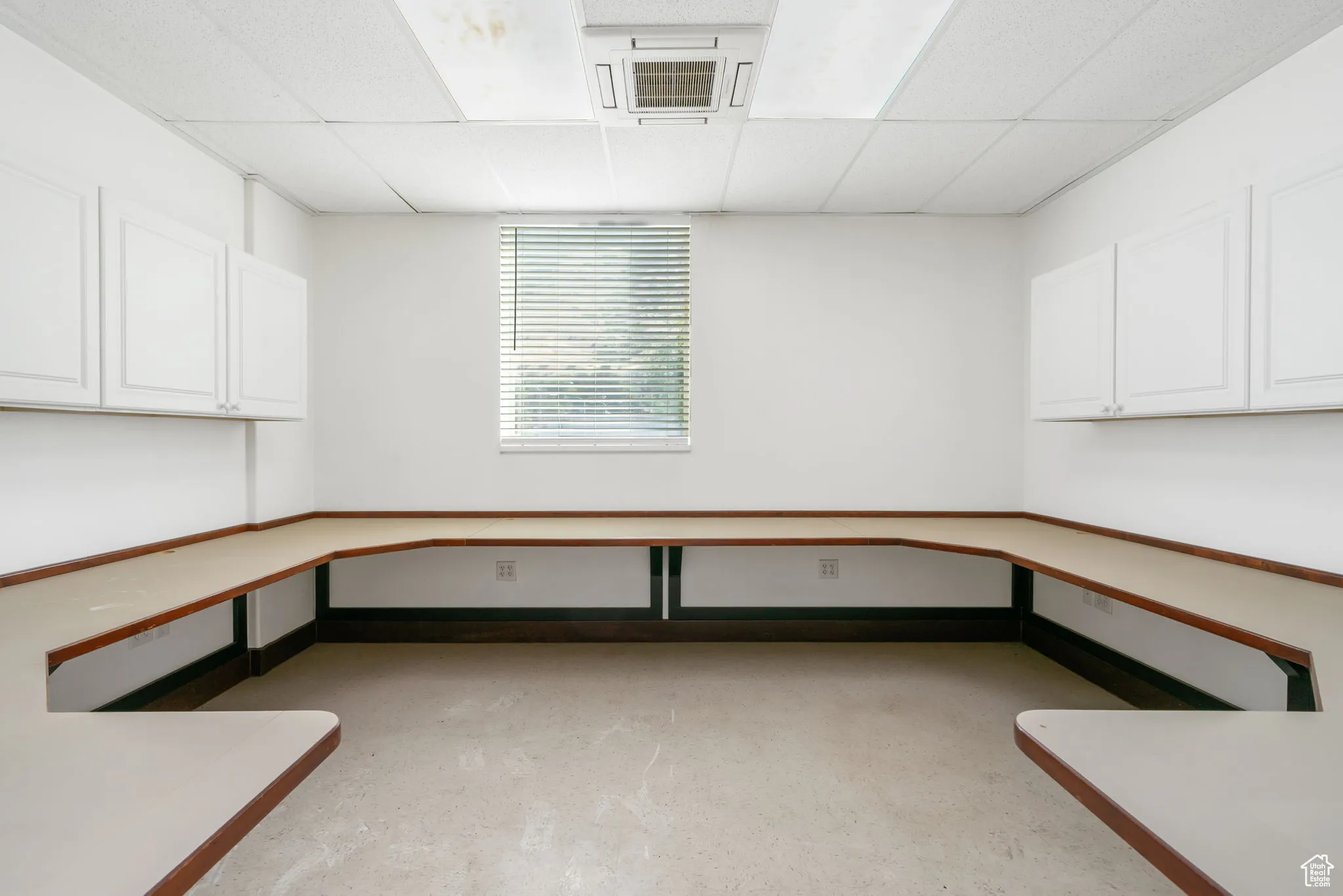 Unfurnished office with a paneled ceiling, cooling unit, and concrete floors