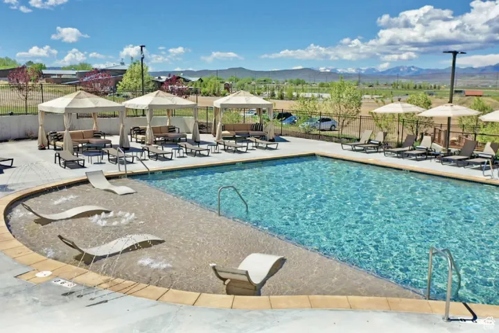 Community pool with a gazebo, a mountain view, outdoor lounge area, and a patio area