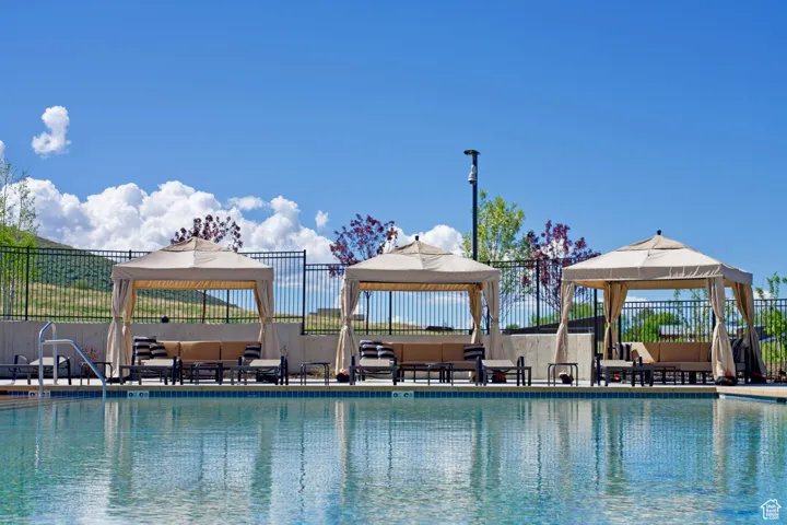 Community pool with a gazebo and outdoor lounge area