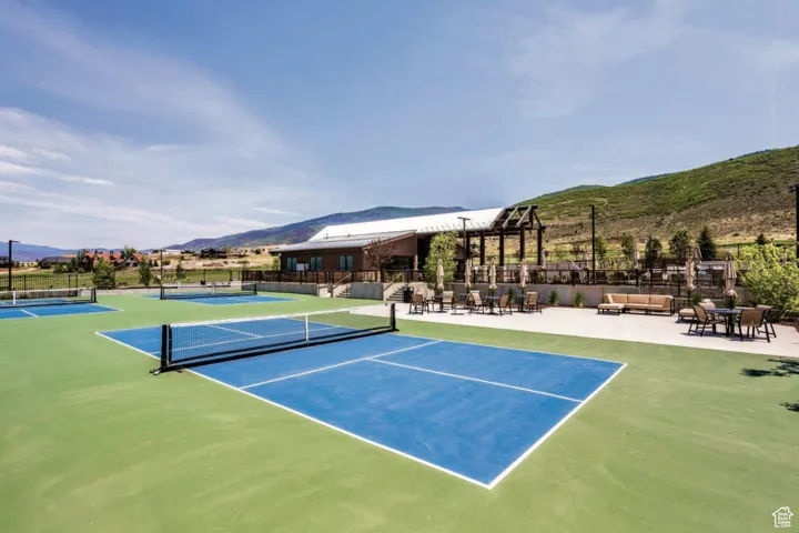View of tennis court featuring a mountain view and outdoor lounge area