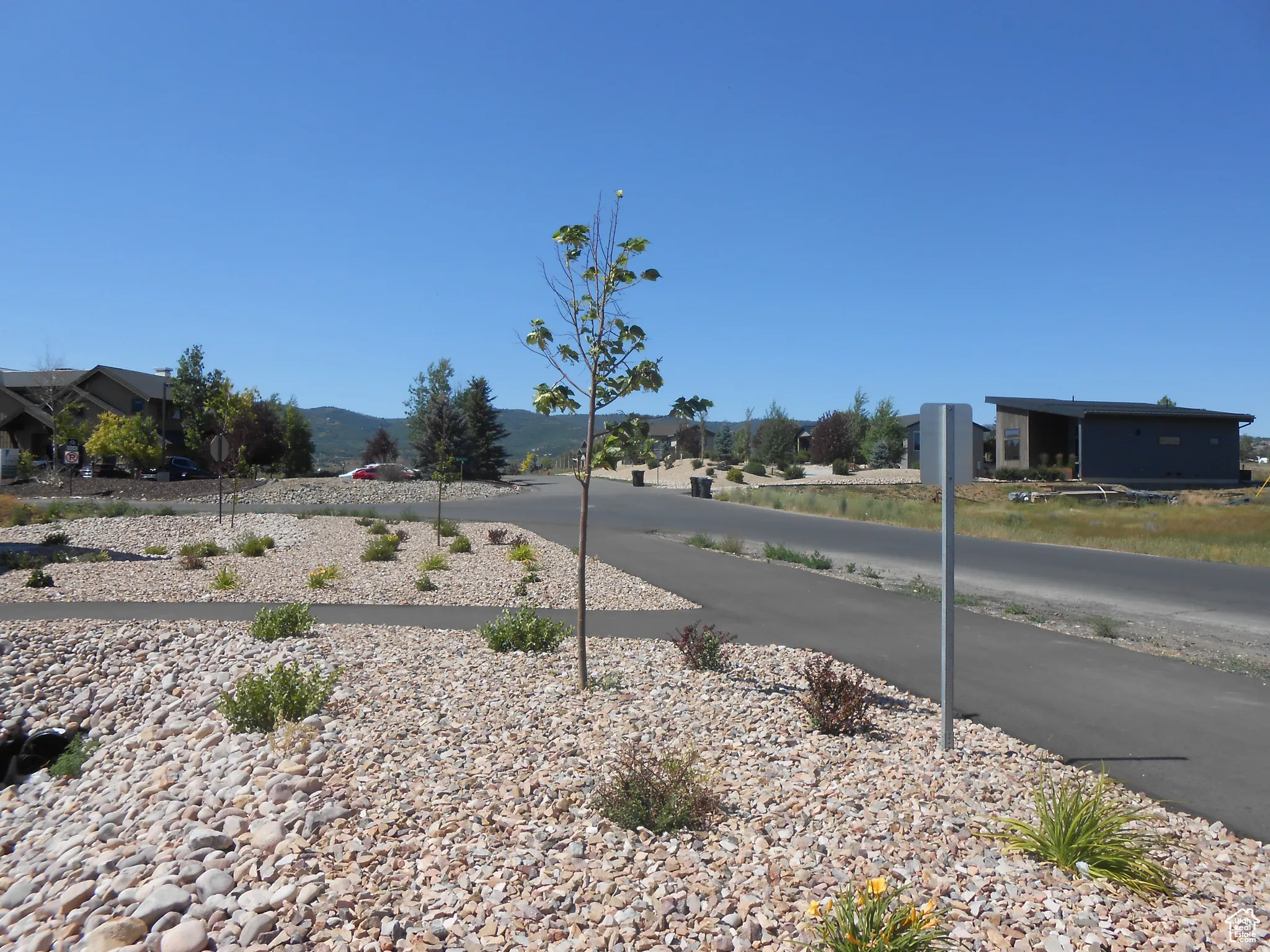 View of asphalt street featuring traffic signs and a mountain view