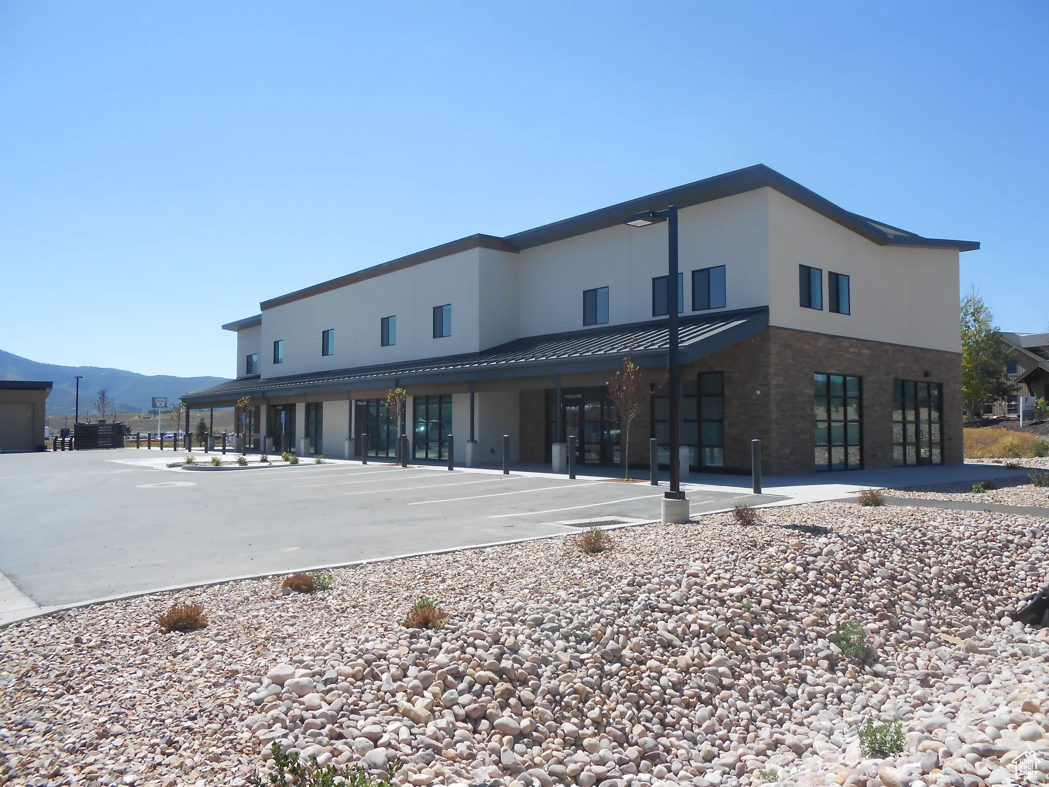 View of building exterior featuring uncovered parking and a mountain view