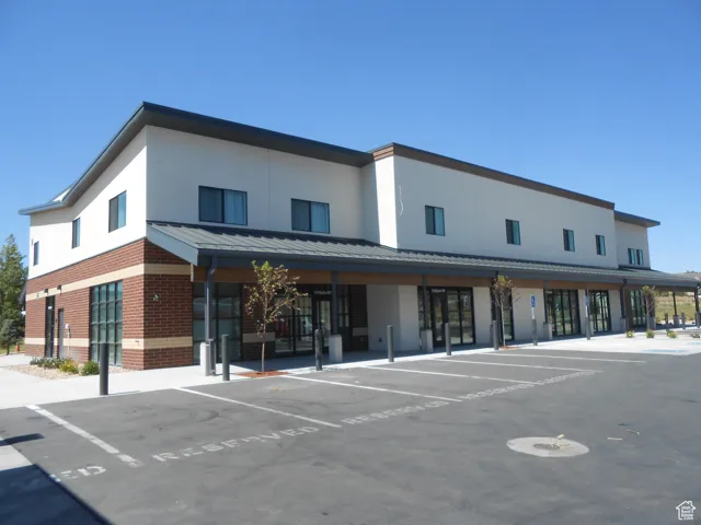 View of building exterior with uncovered parking