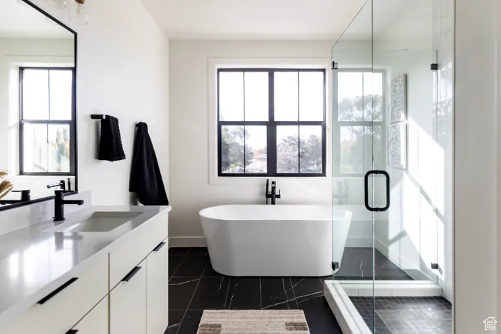 Full bath featuring vanity, a freestanding bath, and a stall shower