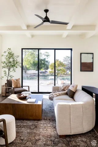 Living area with beamed ceiling and a ceiling fan