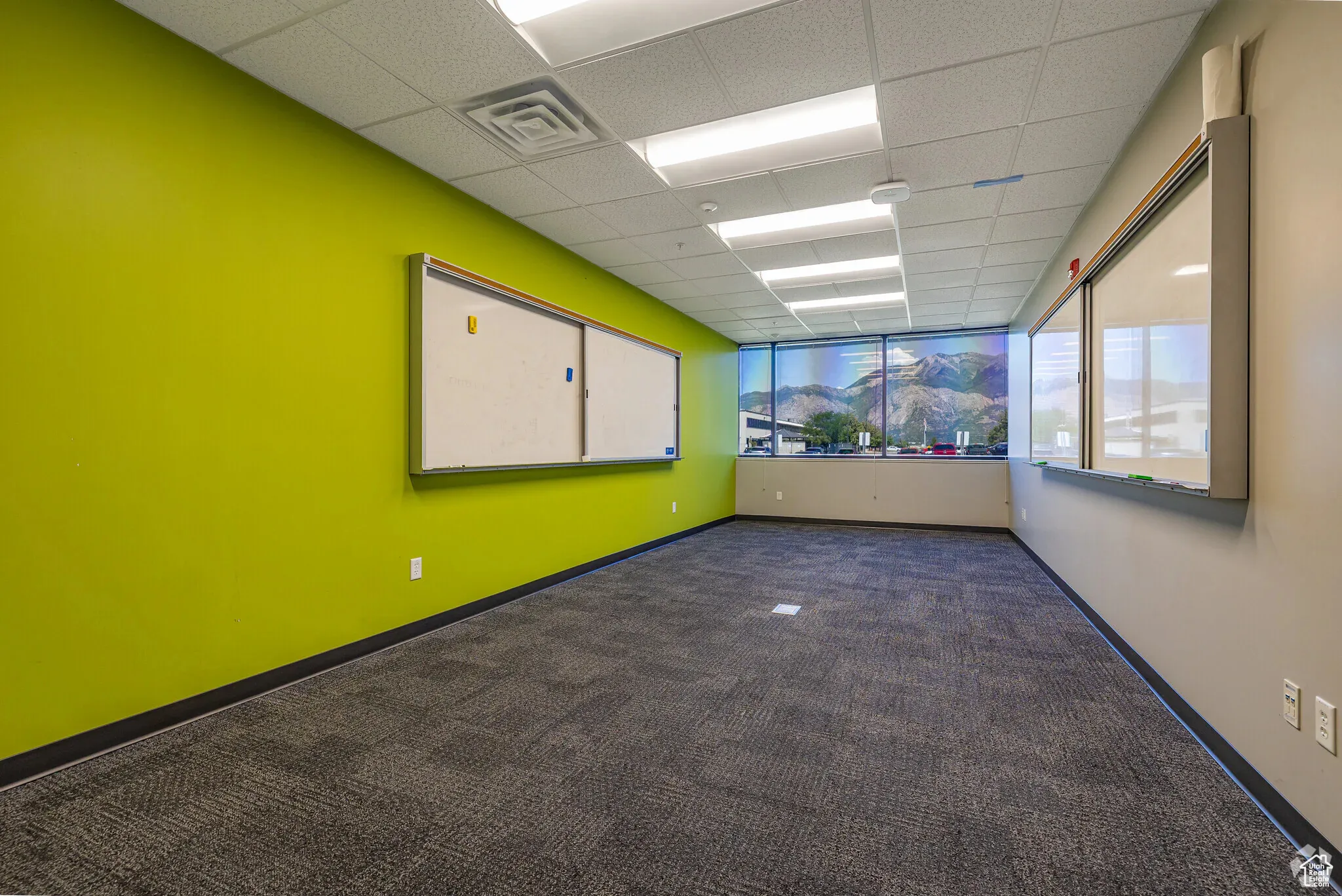 Unfurnished room featuring dark carpet and a paneled ceiling