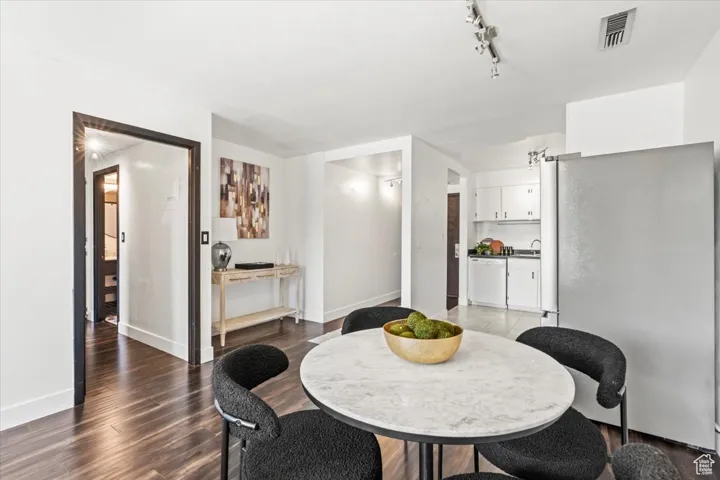 Dining space featuring wood finished floors and rail lighting