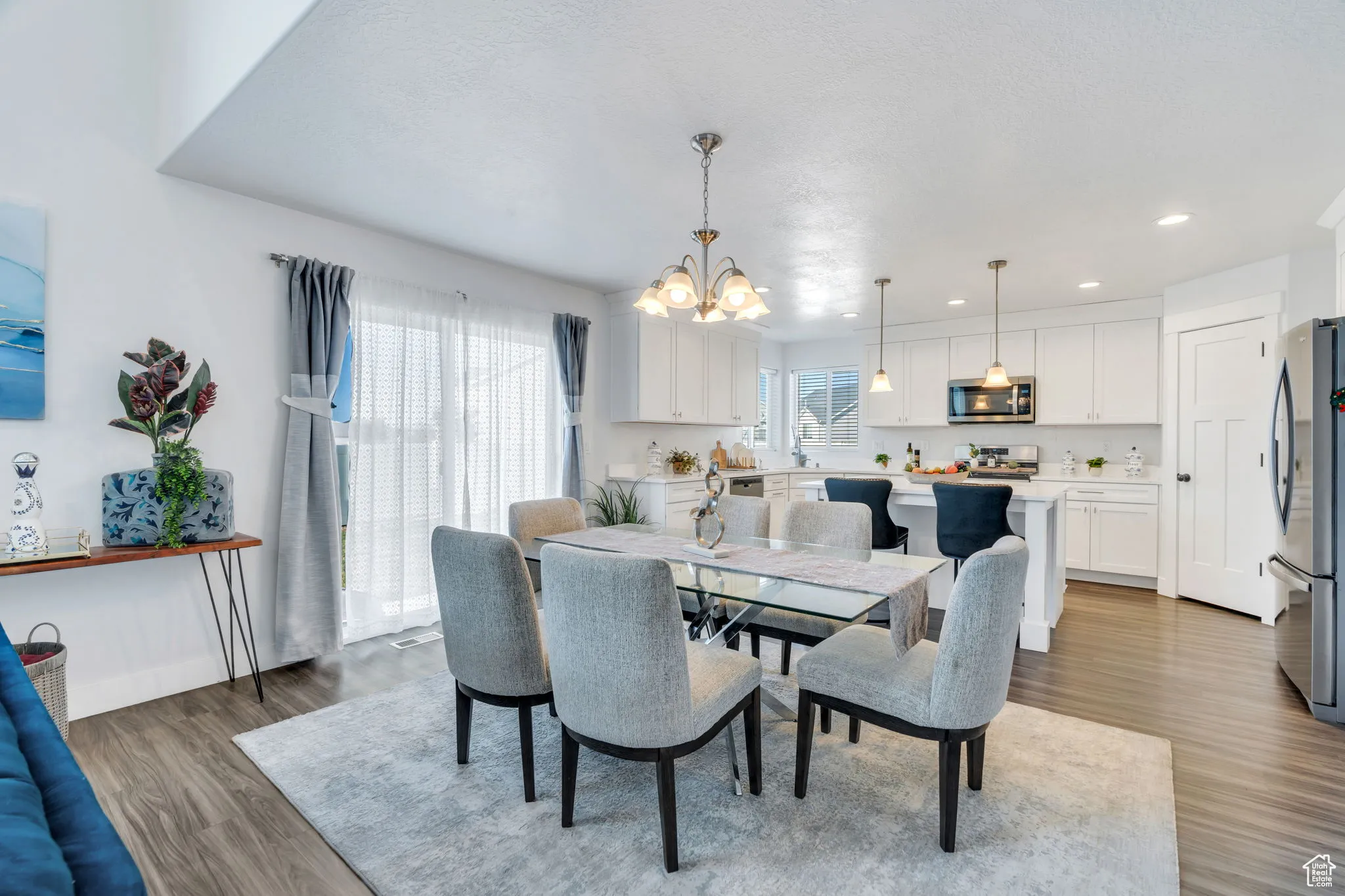 Dining area with a chandelier, wood finished floors, and recessed lighting