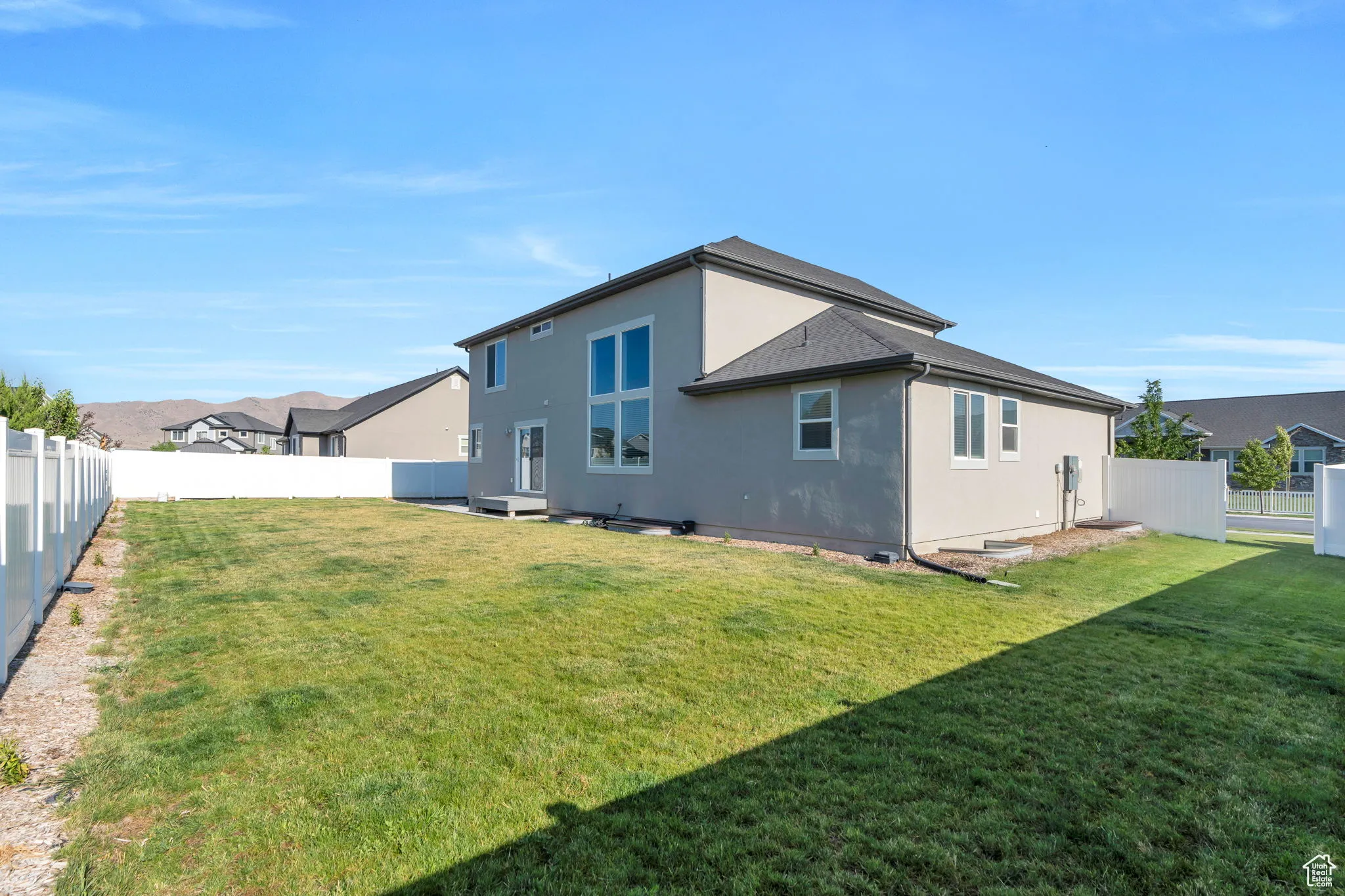 Rear view of house featuring stucco siding and a fenced backyard