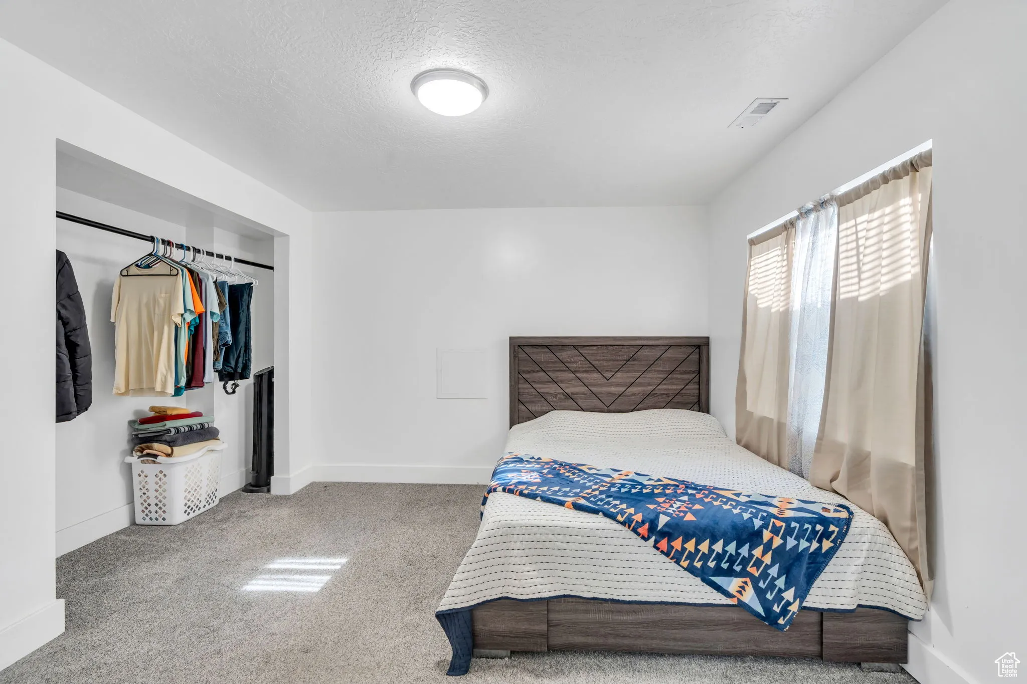 Carpeted bedroom with baseboards and a textured ceiling