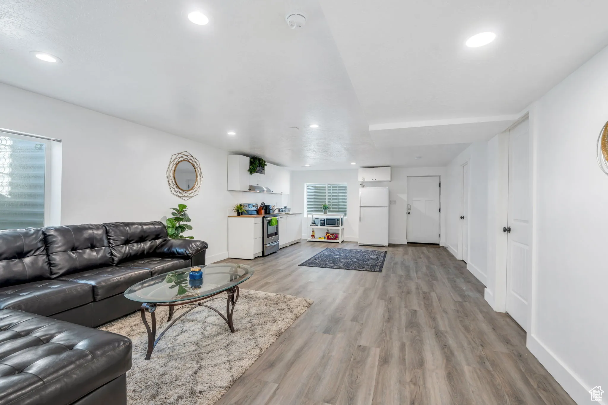Living area with light wood-style floors and recessed lighting