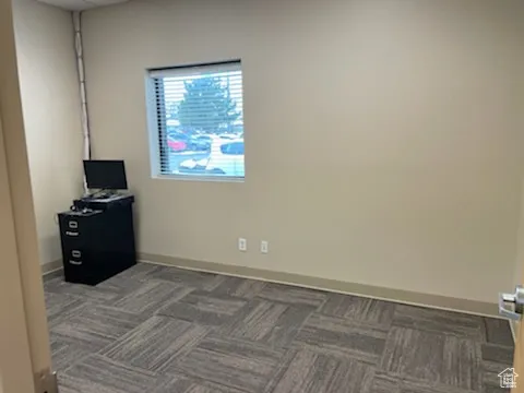 Carpeted spare room featuring baseboards