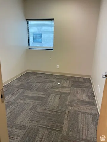Spare room featuring baseboards and carpet flooring